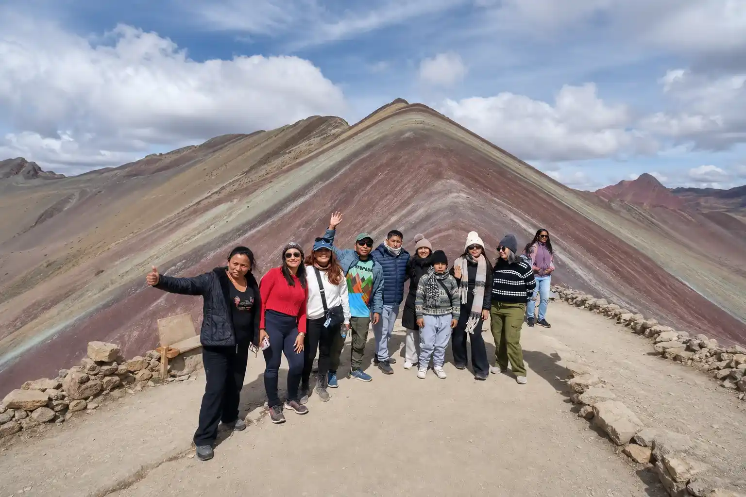 Group of trekkers celebrating at the top of Rainbow Mountain, Peru | Inca Culture Travel 