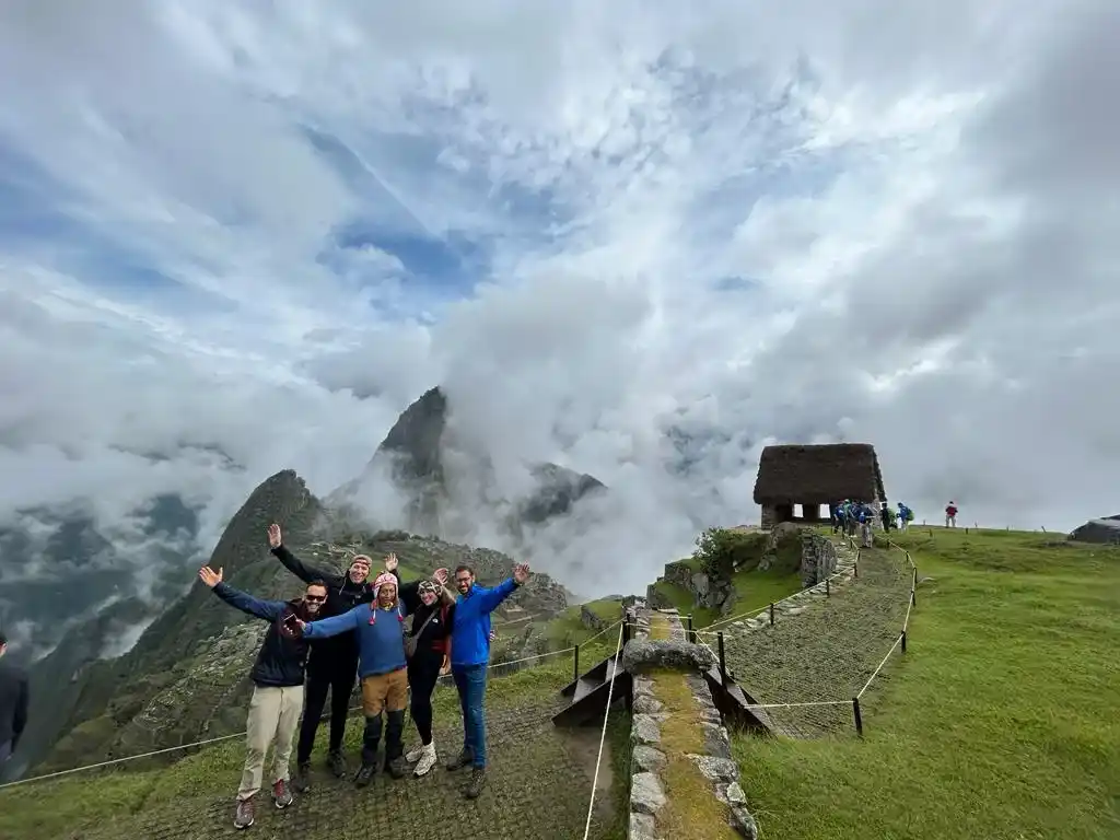 Group of hikers celebrating with open arms along the stone path of the classic Inca Trail to Machu Picchu | Inca Culture Travel