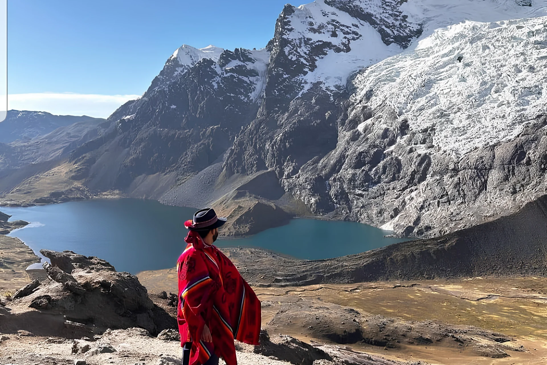 Traveler overlooking a glacial lake and dramatic snow-covered peaks during the Ausangate 7 Lakes Tour.