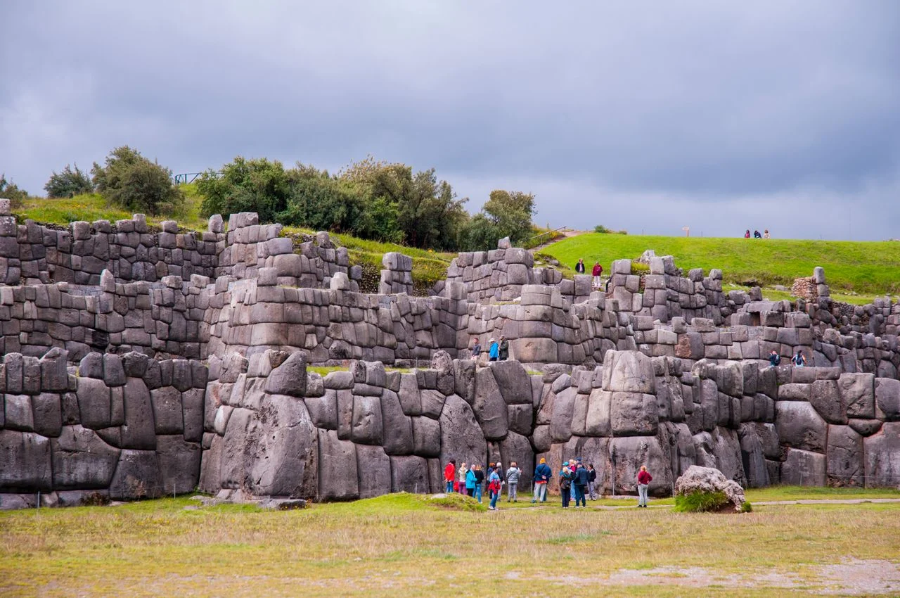 Tourists exploring the ancient stone walls of Sacsayhuamán in Cusco