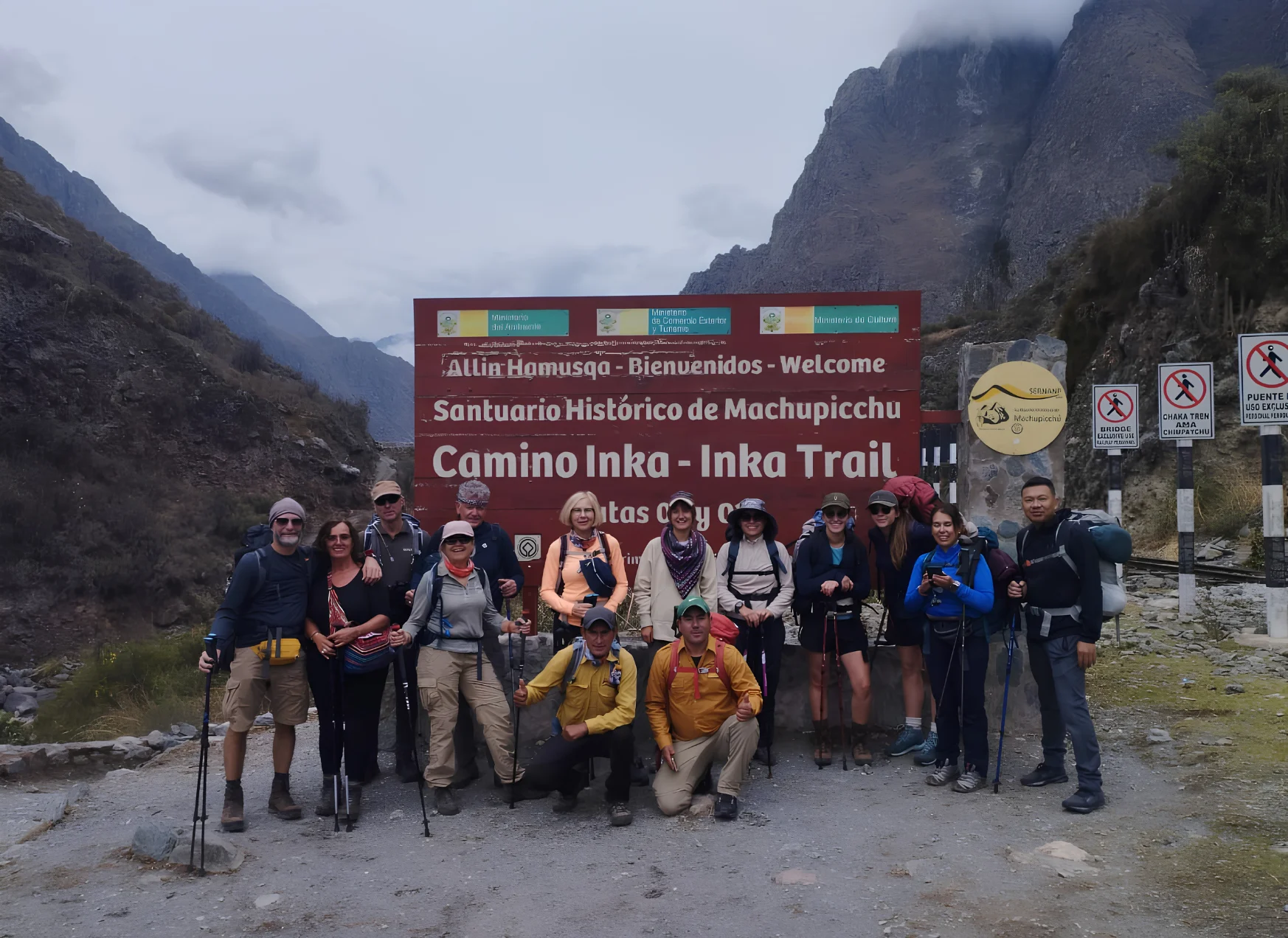 Group of travelers at the Inca Trail entrance sign on the route to Machu Picchu