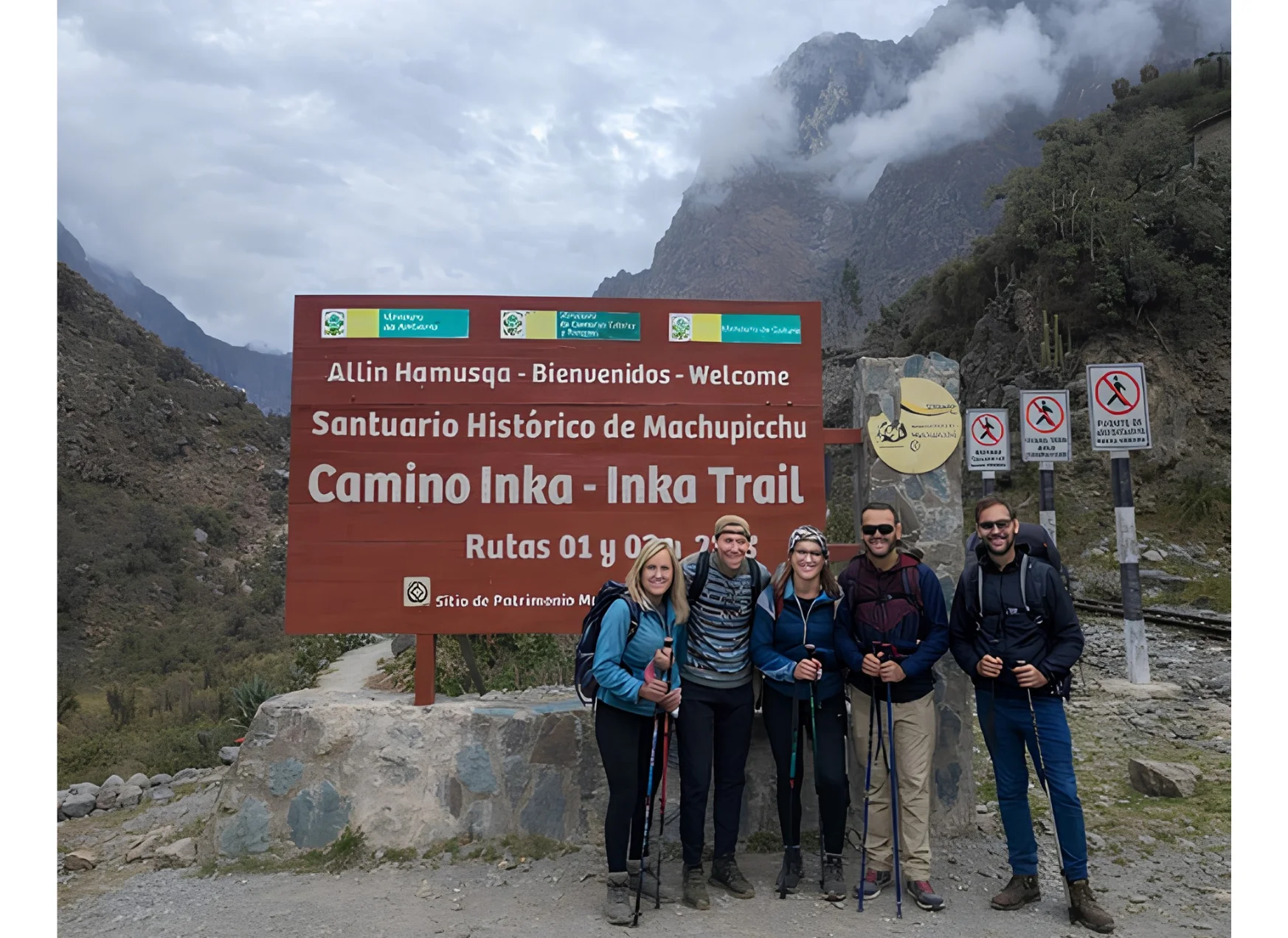 Group of travelers at the Inca Trail entrance sign on the route to Machu Picchu