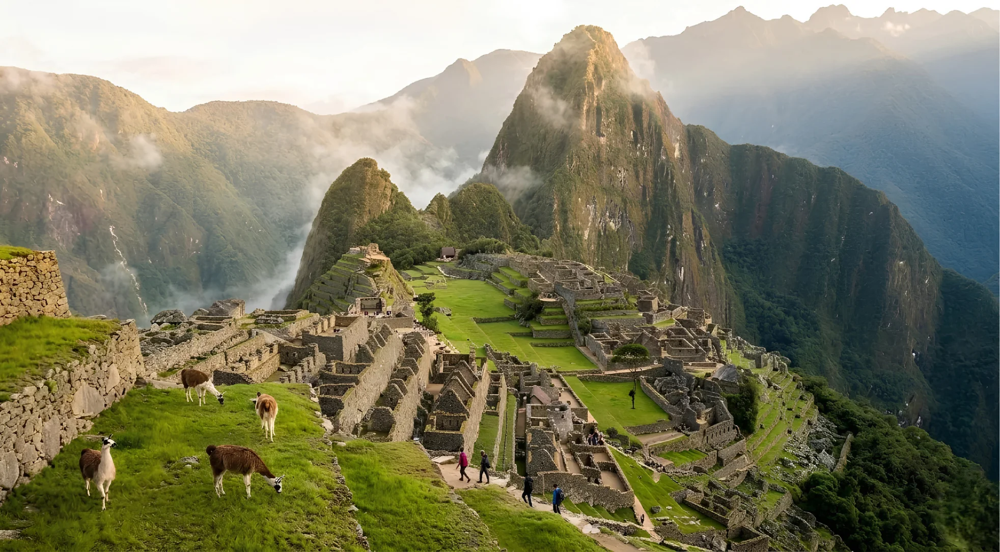 Panoramic view of Machu Picchu with Andean mountains and llamas in the foreground