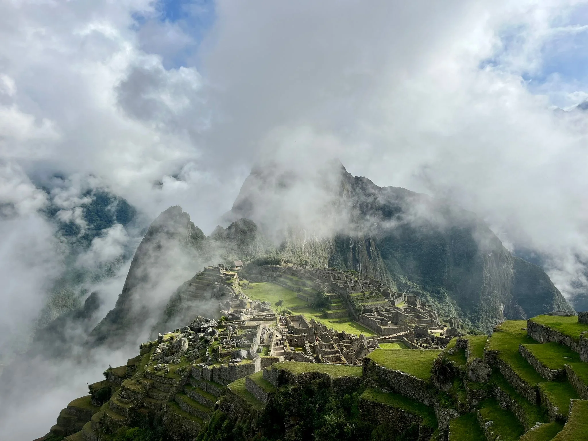 Panoramic view of the Machu Picchu inca citadel partially covered by morning mist and clouds in Cusco | Inca Culture Travel