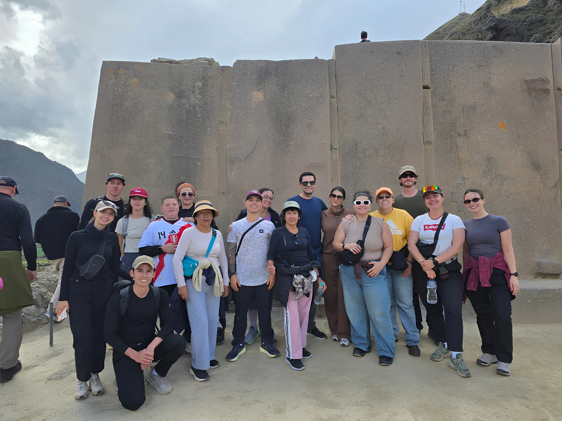 Tour group in front of monumental Inca stonework at the Ollantaytambo archaeological site in the Sacred Valley.