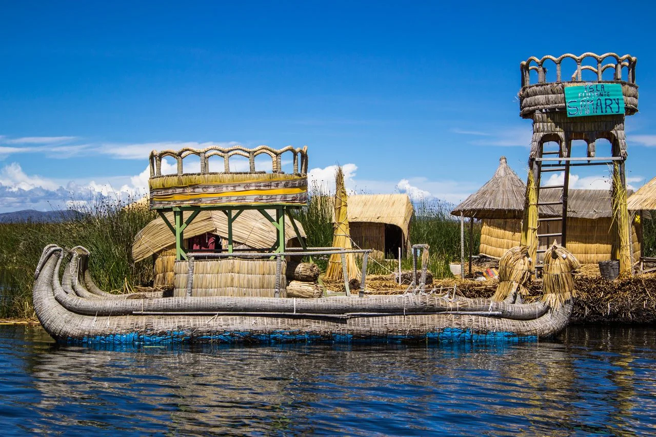 Lake Titicaca with a traditional reed boat and Andean landscape in Puno, Peru