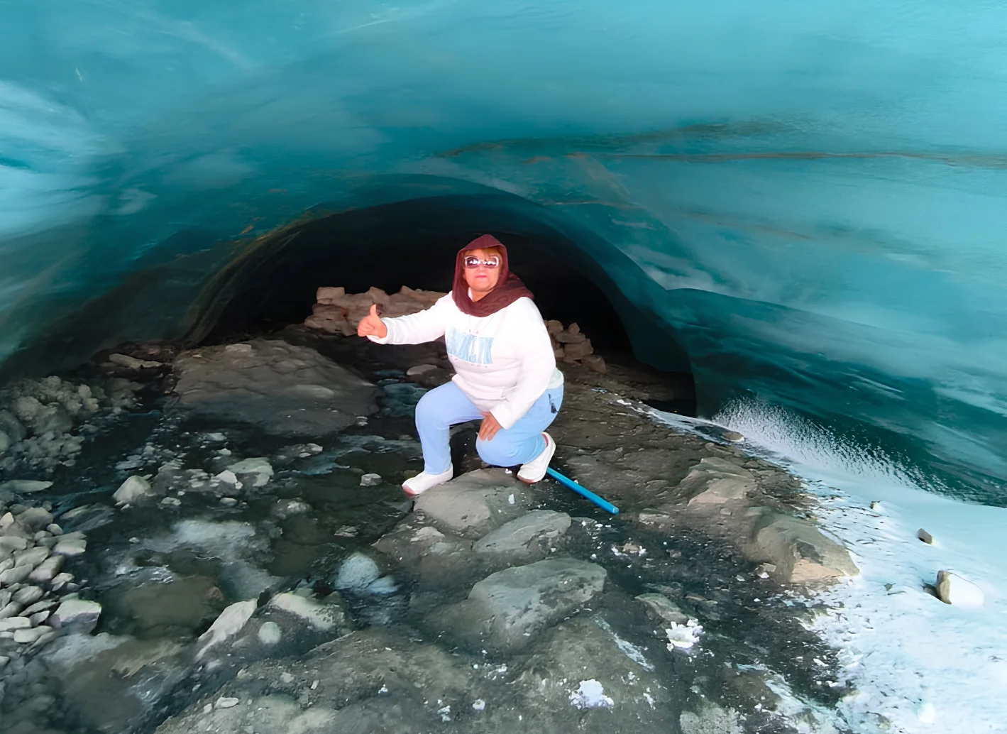 Viajera bajo una formación de hielo azul en el glaciar Quelccaya cerca de Cusco