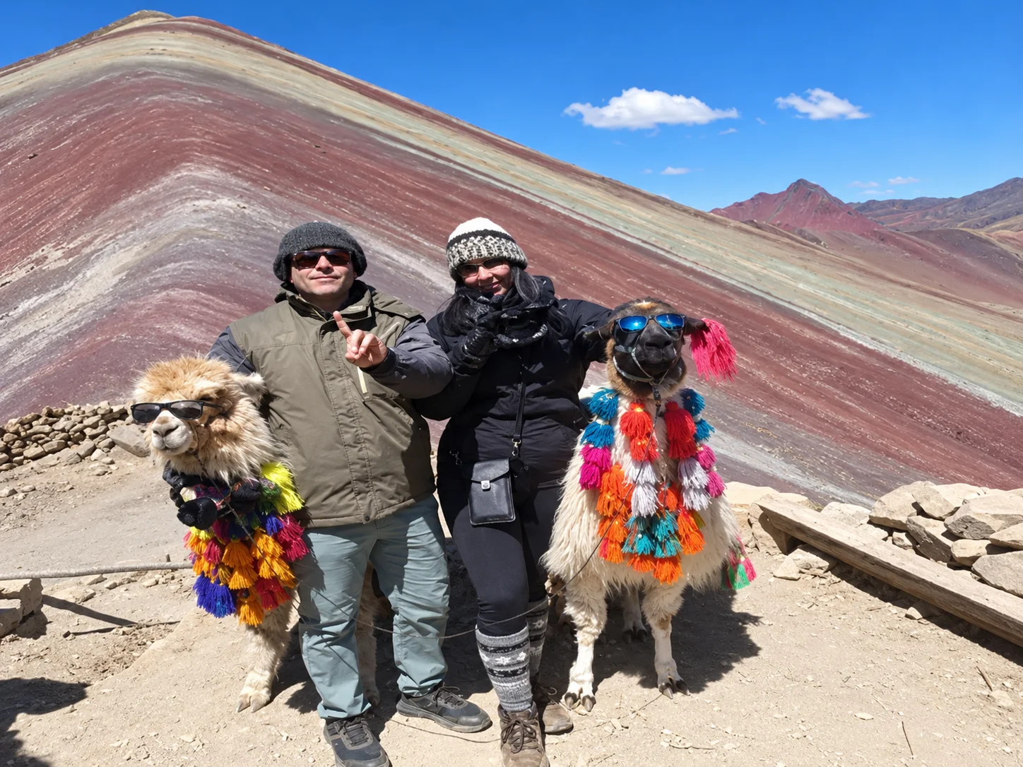 Couple enjoying the panoramic view of Rainbow Mountain and its colorful slopes