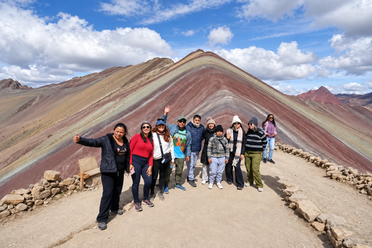 Group of trekkers celebrating at the top of Rainbow Mountain in Peru