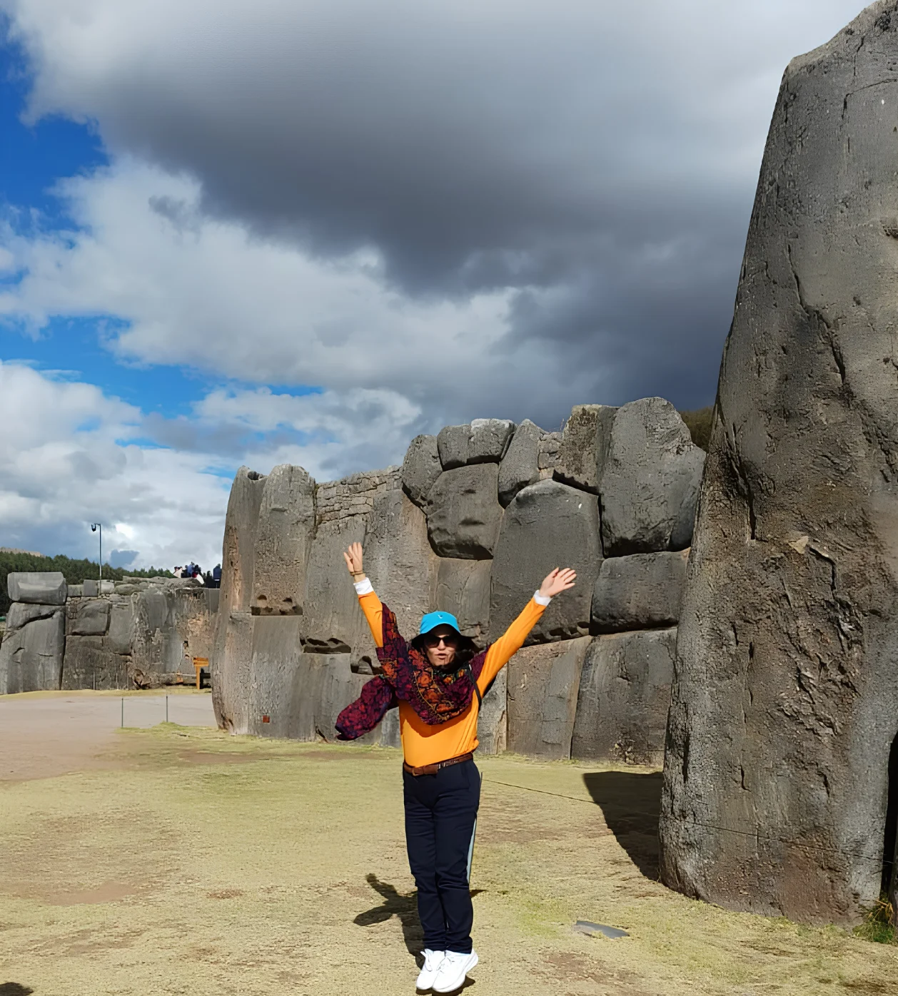 Traveler standing beside the monumental Inca stone walls at Sacsayhuaman near Cusco.