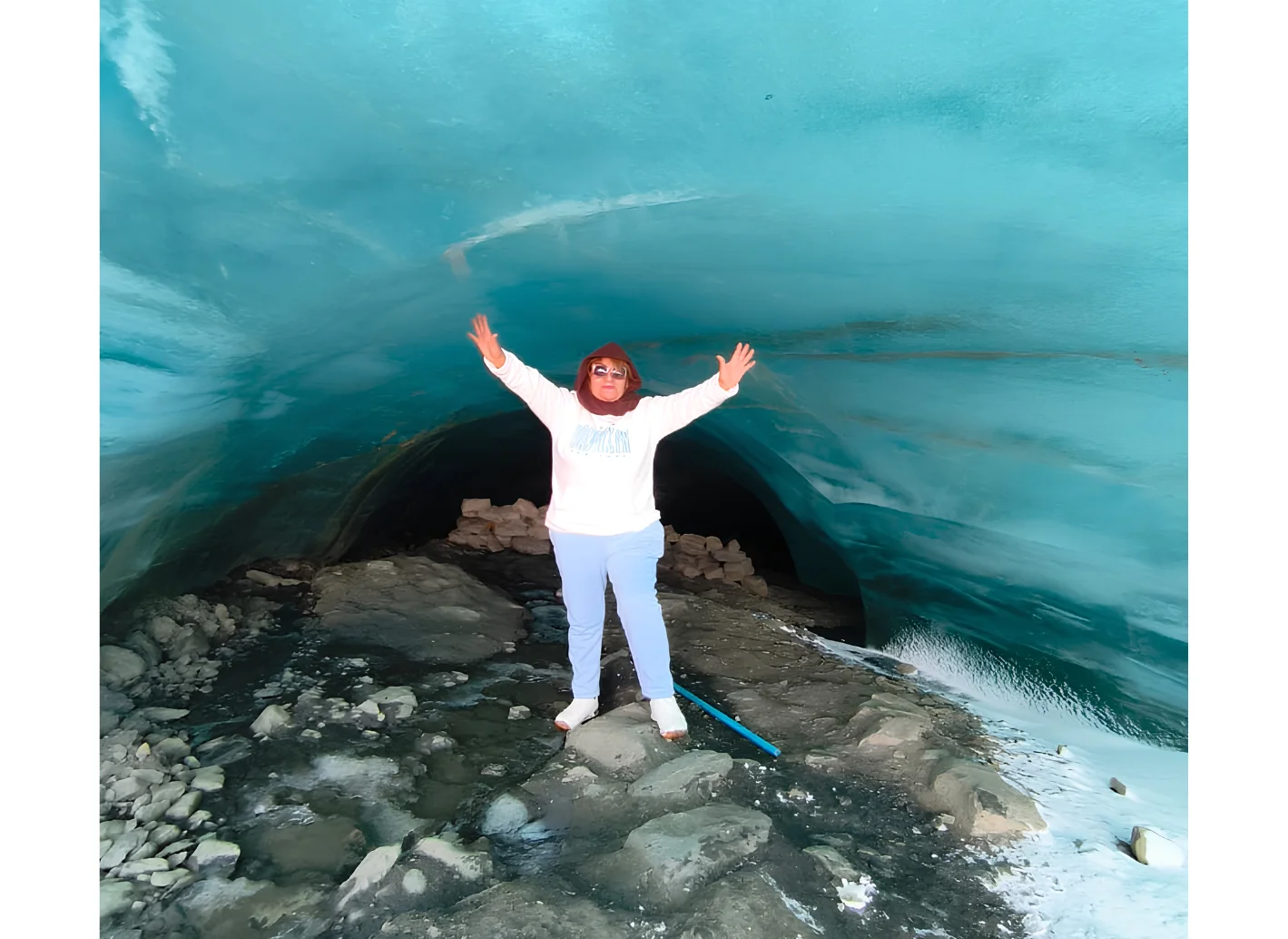 Viajera bajo una formación de hielo turquesa en el glaciar Quelccaya