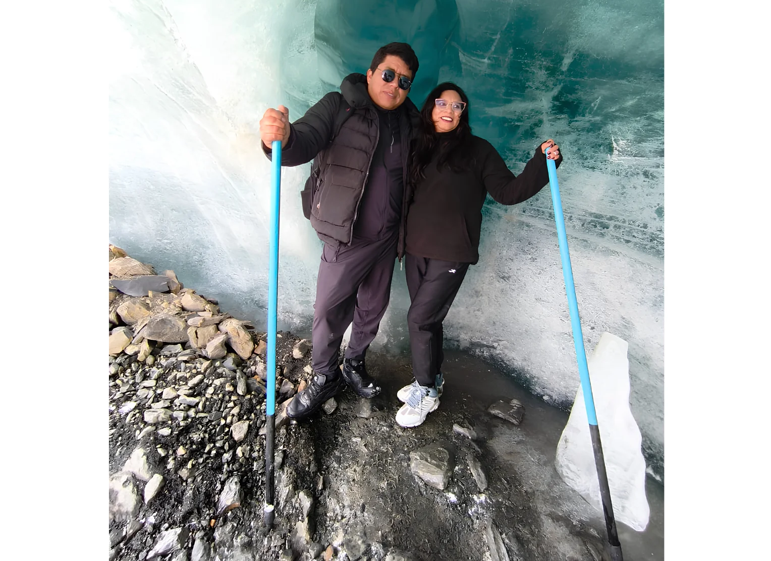 Viajeros junto a un túnel de hielo azul en el glaciar Quelccaya, región Cusco