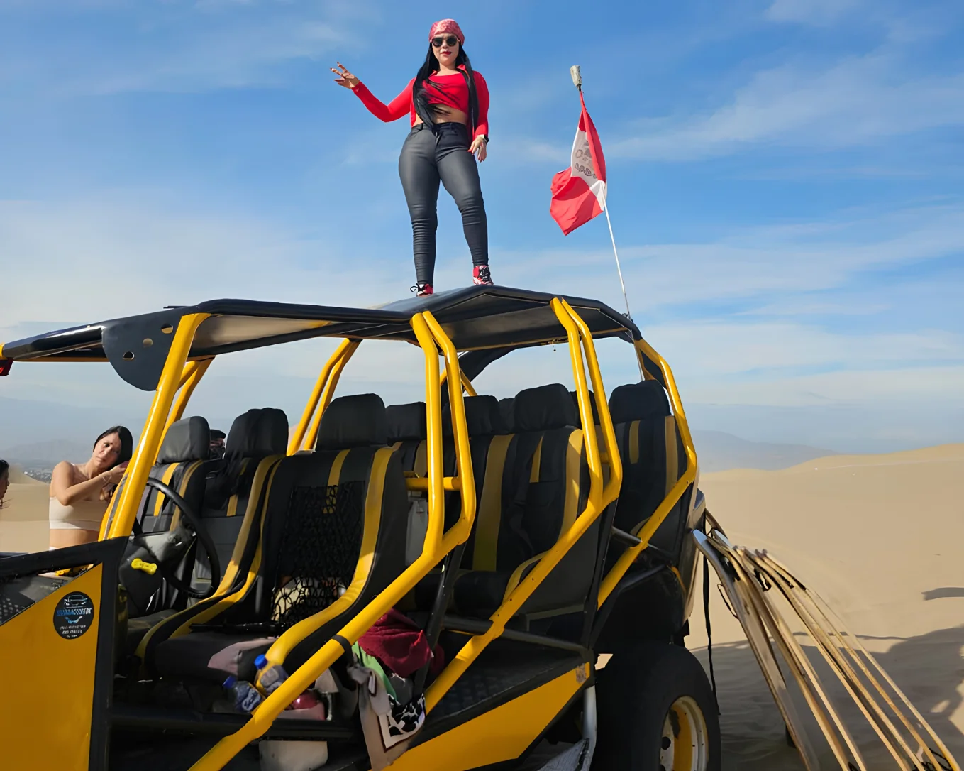 Traveler with a dune buggy surrounded by the desert landscape of Huacachina.