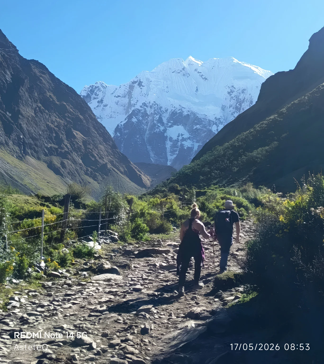 Travelers hiking through an Andean valley with snow-covered mountains on the Salkantay Trek 5 Days.