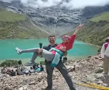 A couple of hikers walking along the Humantay Lagoon trail with panoramic views of the Andes | Inca Culture Travel