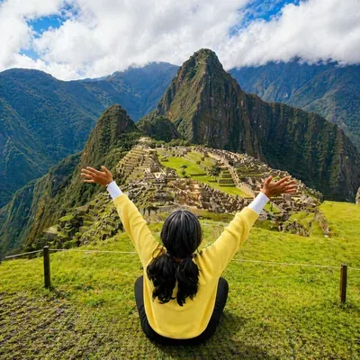 Mujer levantando los brazos mientras contempla la ciudadela de Machu Picchu durante el Camino Inca Corto | Inca Culture Travel