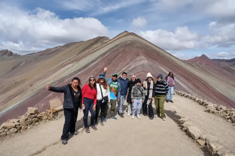Group of trekkers celebrating at the top of Rainbow Mountain, Peru | Inca Culture Travel 