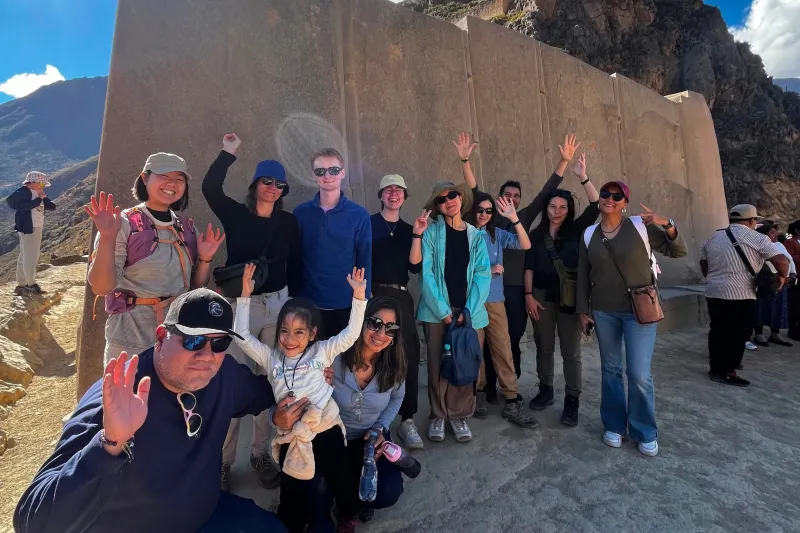 Tour group visiting the monumental Inca stone walls at Ollantaytambo during a Super Sacred Valley Tour from Cusco.