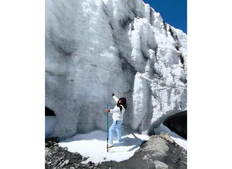 Viajera junto a una imponente pared de hielo del glaciar Quelccaya cerca de Phinaya