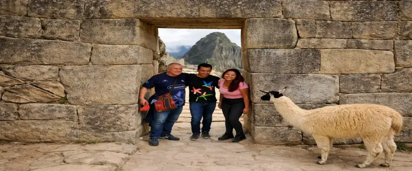 Travelers posing with a llama at Machu Picchu