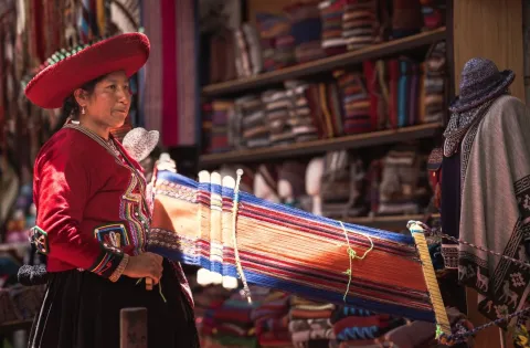 Local woman demonstrating traditional weaving and textile techniques in Chinchero